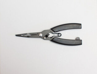 A black pair of scissors for tying hooks is placed on a white background.