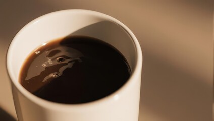 Close-up of a white mug filled with dark coffee. Sunlight casts a shadow