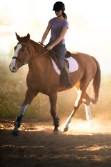 A young girl riding a chestnut horse in rural countryside.