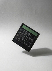 Modern digital calculator levitating in the air with soft shadow, sleek business accounting equipment.