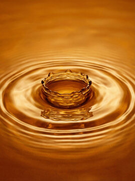 Stunning golden liquid crown splash with ripples on a honey-colored surface. Perfect for luxury or beverage concepts.