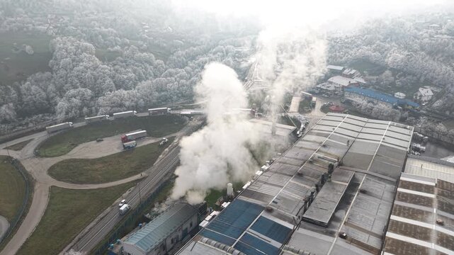 Drone Shot of Steam From Cooling System in Factory Making Hoar Frost on Landscape and Forest on Cold Winter Day