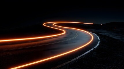 A winding, illuminated road at night. The long exposure reveals light trails