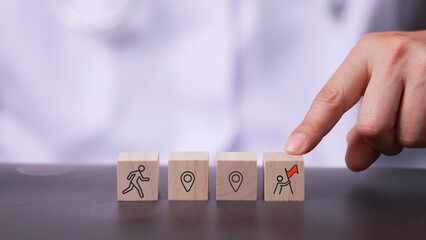 Symbolic wooden blocks representing happy career progress with hand selecting goal and success concept