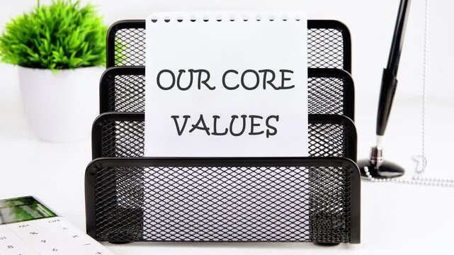 The conceptual text of OUR CORE VALUES appears on a piece of paper in the stand. Business and our core values concept