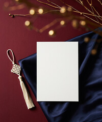 Vertical blank card with Korean traditional tassel and silk fabric on red background