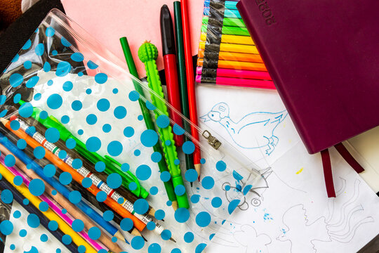 various stationery, colored pencils, pencil case with pens, diary, notebook with bookmarks, colored, white paper, tosser, creativity, school supplies, sketches of drawings
