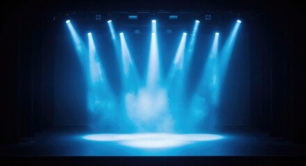 Blue stage spotlights illuminating a dark empty performance area with visible light beams and atmospheric haze for a concert or show production.