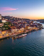 Fototapeta premium Aerial view of Porto, Portugal, showcasing the Douro River and cityscape at sunset.