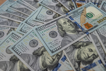 Pile of hundred US dollar bills, representing wealth and economic power.