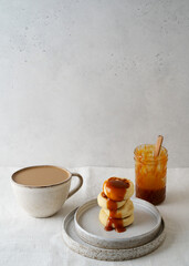 Fried cheesecakes pancakes on plate with caramel syrup