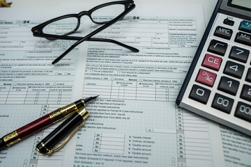 Financial analysis with 1040 form, calculator and pen for 2025&ndash;2026 income review