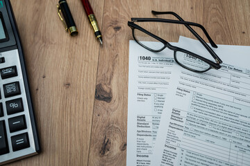 Financial analysis with 1040 form, calculator and pen for 2025&ndash;2026 income review