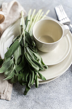 Close-up of a stack of crockery with fresh sage leaves