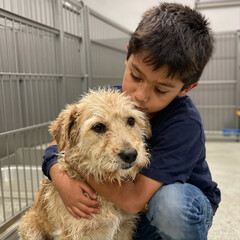 Boy hugging a wet dog in a shelter