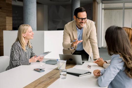 Business team in corporate meeting using laptop at office table