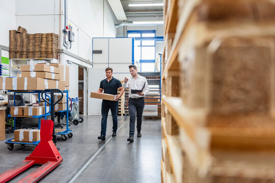 Business meeting in a production hall with workers and logistics