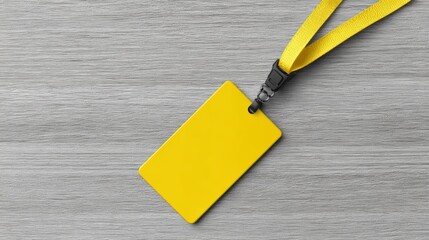 Yellow identification badge with lanyard placed on a wooden surface, showcasing a blank space for personal information or branding, ideal for events or conferences