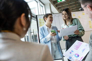 Business team collaborating and analyzing documents in modern office