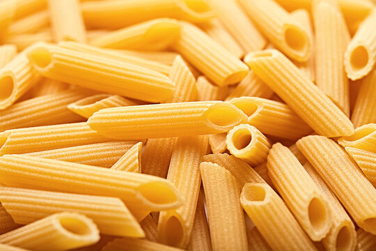 Full frame close-up of a stack of Uncooked Penne Rigate Pasta