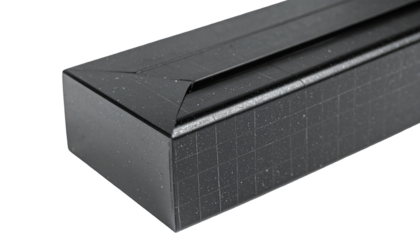 Close-up of a geometric black object with a squared, textured surface