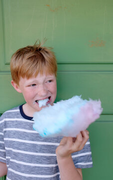 Child eating cotton candy at Tivoli fun fair in Copenhagen Denmark