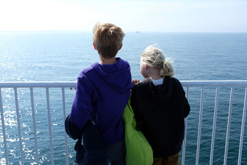 Back view of two children on ferry looking at Baltic Sea Rodby Denmark