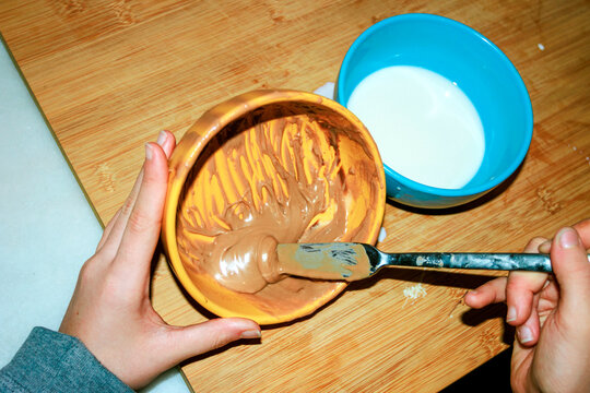 Hands preparing homemade peanut butter dessert in a kitchen