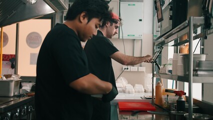 Chefs working in dark kitchen, preparing food for delivery and takeaway service