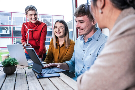 Business team collaborating in modern office with windmill model