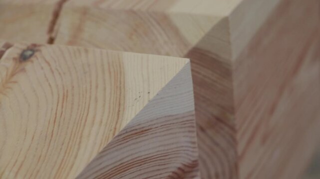 Extreme close-up of a precisely cut timber joint, highlighting angular geometry and detailed wood grain patterns on the surface of the lumber