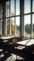 Empty desks and chairs in a classroom with sunlight streaming through large windows