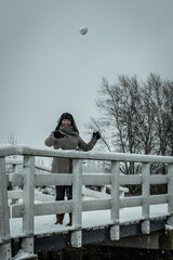 Dutch winter scene lady throws snowball while snowing as storm system brings unusually heavy snowfall in the Netherlands. Traditional game snowball fight in the snow