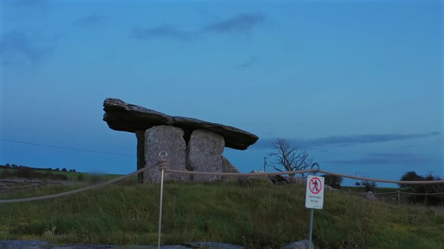 Profile view of Poulnabrone Dolmen standing quietly in Burren National Park as evening light gradually fades