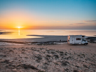 Camper van parked on rocky coastline at sunset in Djerba Tunisia, remote travel lifestyle, quiet seascape, freedom, adventure, vanlife