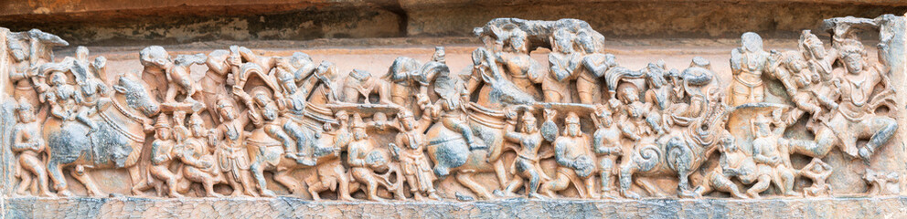 Detailed stone carving Halebeedu ancient temple Karnataka India showing warriors deities animals intricate sculptural art symbolizing heritage culture devotion