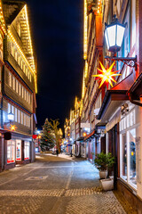 Historic townscape at night with festive lights, stars and illuminated Christmas tree in the center