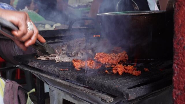 Taco vendor grilling beef jerky at a street food stall. Close-up of the grill.