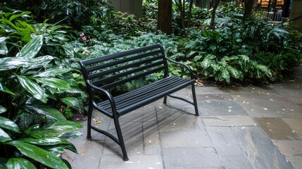 Obraz premium A black metal bench sits in a lush garden.