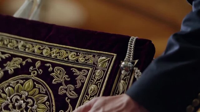 Close-up of a Torah scroll being lifted, highlighting sacred craftsmanship and reverence.