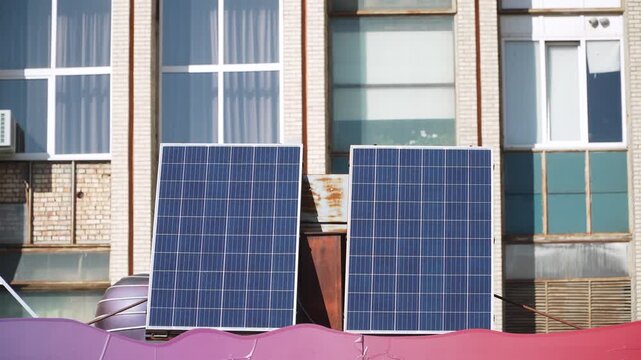 Two solar panels are located on roof of extension next to old industrial building. Implementing modern, sustainable, energy-efficient technologies in older parts of the city.