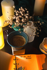 Cozy workspace with to-do list, coffee and candles &ndash; planning and mindfulness concept