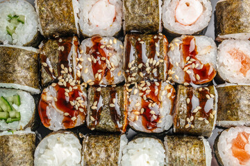 Assorted sushi rolls with eel sauce sesame and seafood top view © Надія Коваль