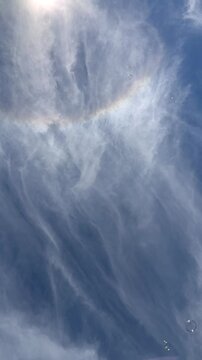 blue sky filled with wispy clouds with bubbles floating slowly by