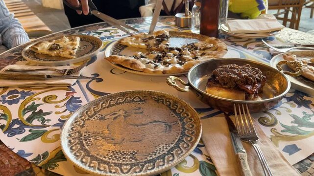 A delicious mushroom pizza served with scissors at a stylish restaurant and a traditionally presented meat dish. A luxury restaurant experience, gourmet flavors, and a high-quality table presentation 