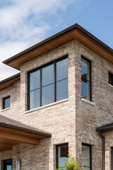 Obraz premium Close-up capturing architectural details: brick, large windows, and modern design.