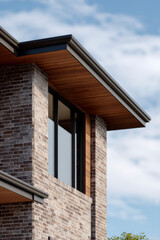Obraz premium Exterior shot of a building with brick walls and wooden paneling on the roof.