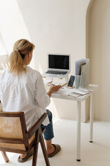 Back view of woman working at minimalist home office desk