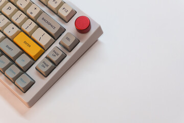 White mechanical keyboard with bright Enter key on white background, minimalism, keyboard buttons. A keyboard with a yellow key. High quality
