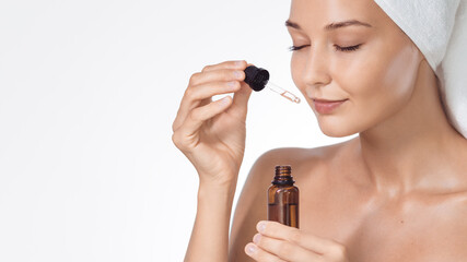 Applying Face Serum: Towel-Wrapped Woman With Amber Glass Pipette